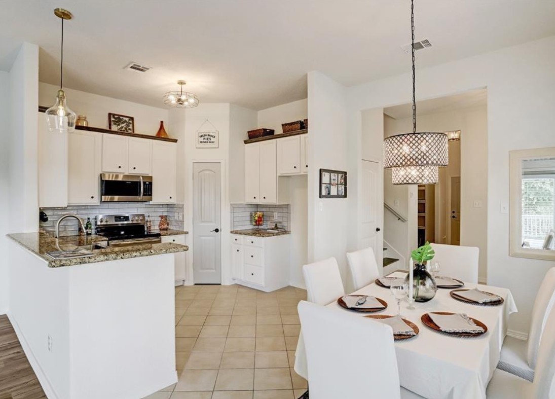 277 Capetown Conroe, TX 77356 - Photo 4 of 10 Open-concept kitchen and dining area featuring granite countertops, stainless steel appliances, soaring ceilings, and a seamless flow that's perfect for everyday living and entertaining.