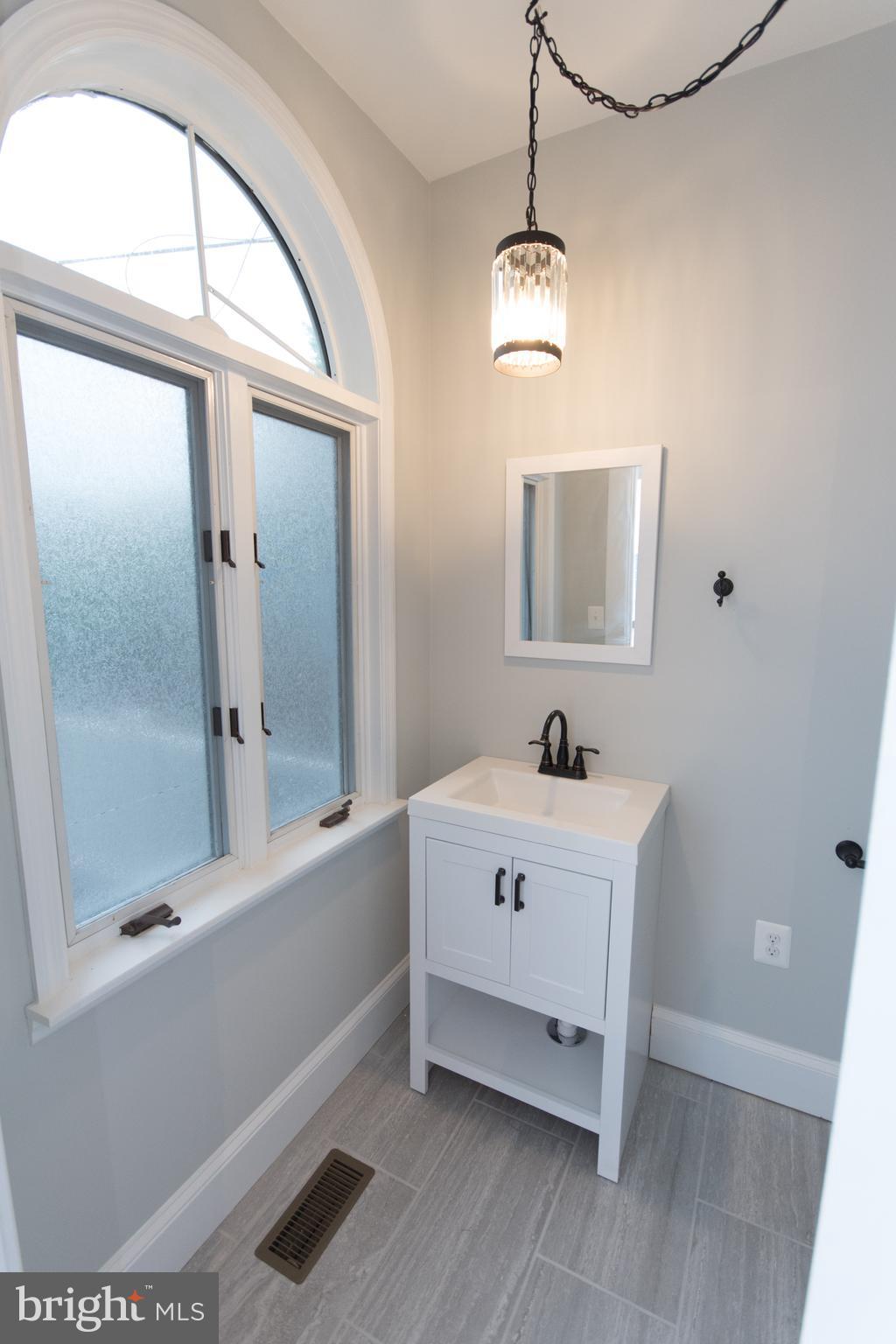 511 Dunkirk Road Baltimore, MD 21212 - Photo 15 of 27 a bathroom with a sink a mirror and a bathtub