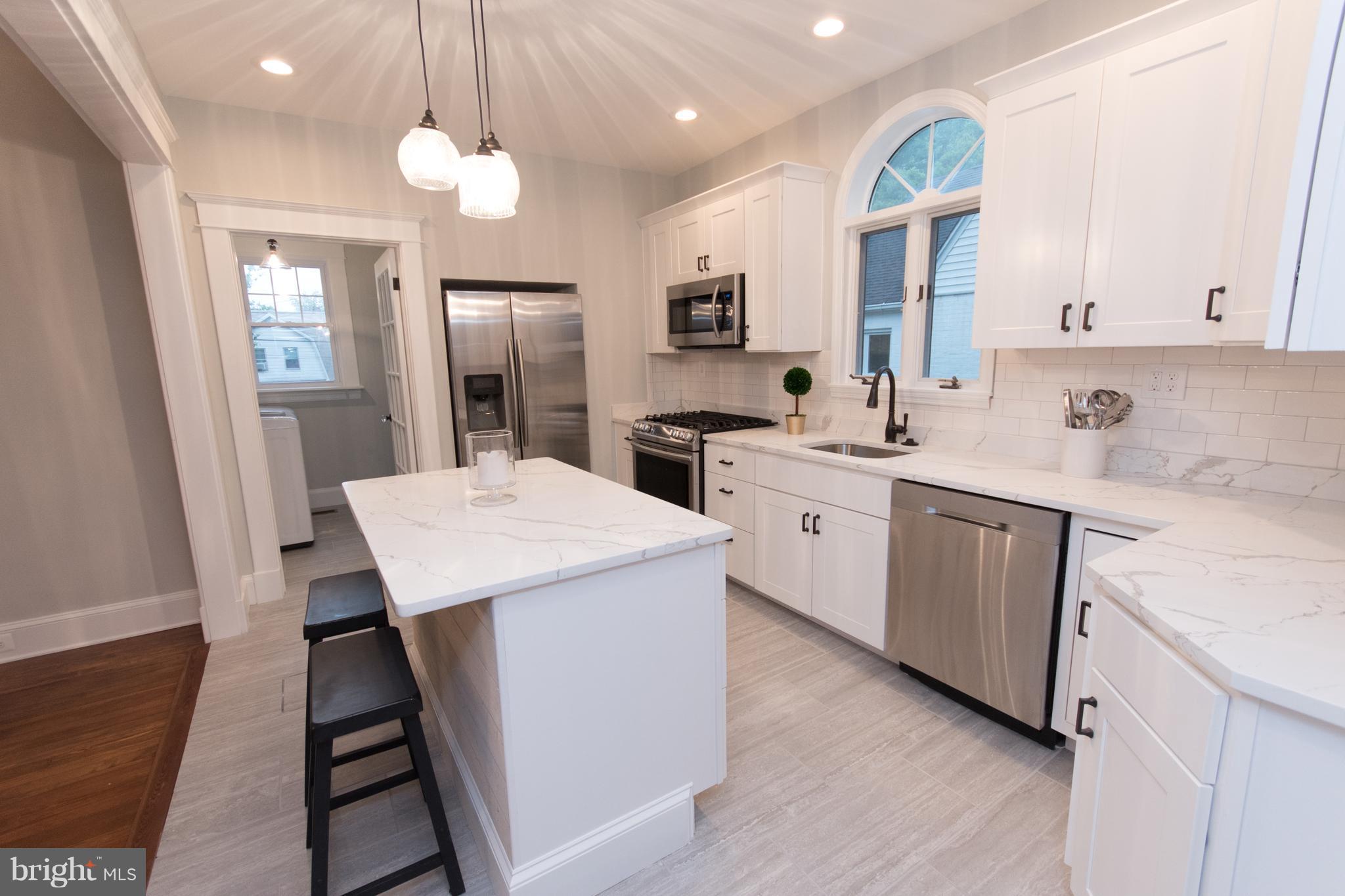 511 Dunkirk Road Baltimore, MD 21212 - Photo 5 of 27 a kitchen that has a lot of cabinets in it and wooden floors