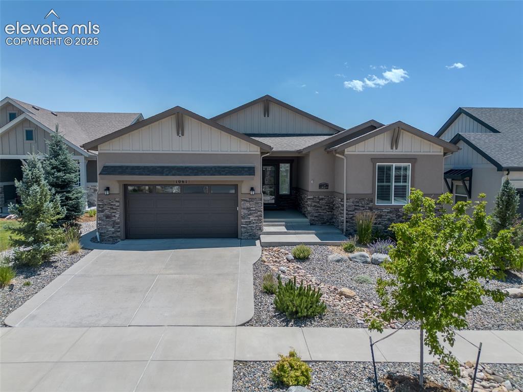 1061 Native Dancer Terrace Colorado Springs, CO 80921 - Photo 1 of 50 Contemporary ranch-style exterior featuring a neutral stucco facade and stacked stone accents