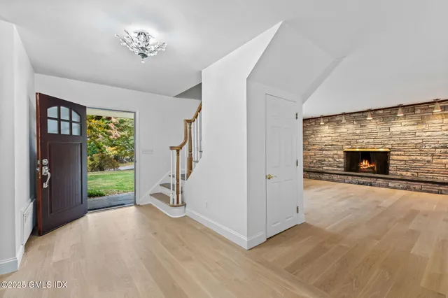 a view of empty room with fireplace and wooden floor