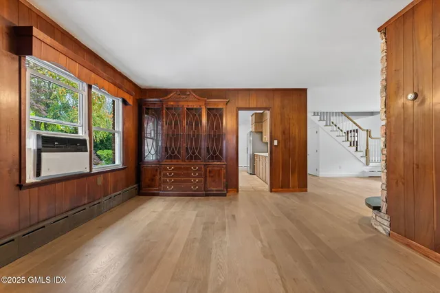 a living room with a large window and a wooden floor