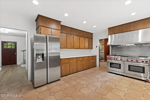a kitchen with stainless steel appliances a stove a sink and a refrigerator