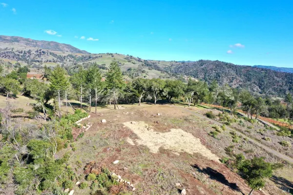 a view of a dry yard with mountains in the background