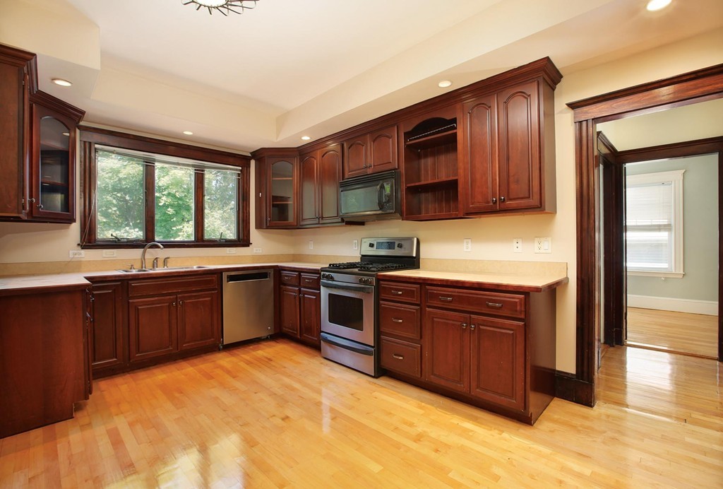 14-16 Presentation Road Boston, MA 02135 - Photo 2 of 12 a kitchen with stainless steel appliances granite countertop a stove sink and cabinets
