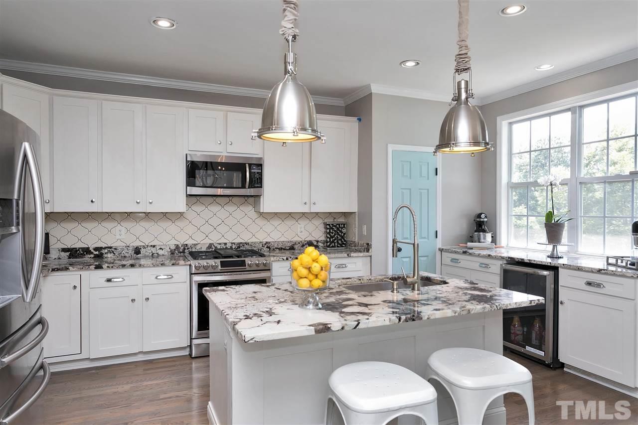 7206 Doverton Court Raleigh, NC 27615 - Photo 1 of 23 a kitchen with a stove a sink a center island and cabinets