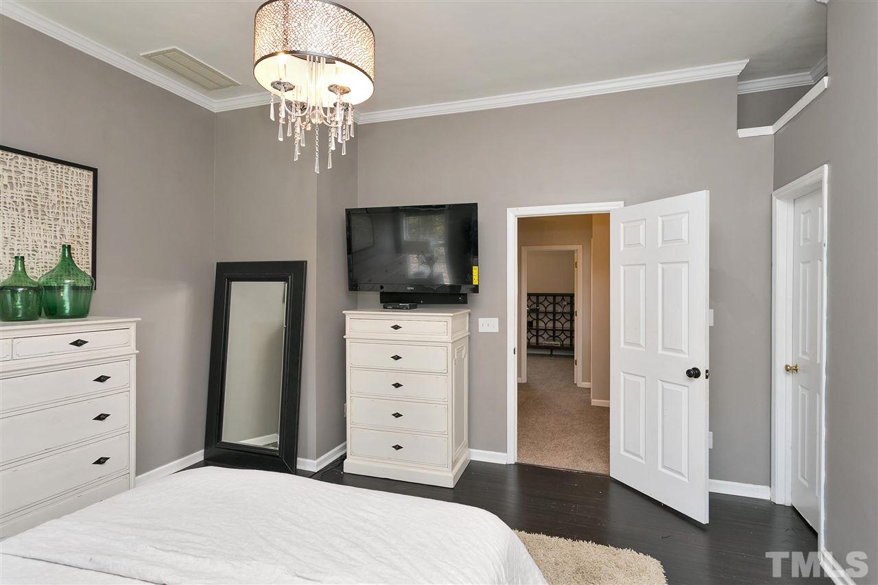 7206 Doverton Court Raleigh, NC 27615 - Photo 13 of 23 a spacious bedroom with a bed and a flat screen tv