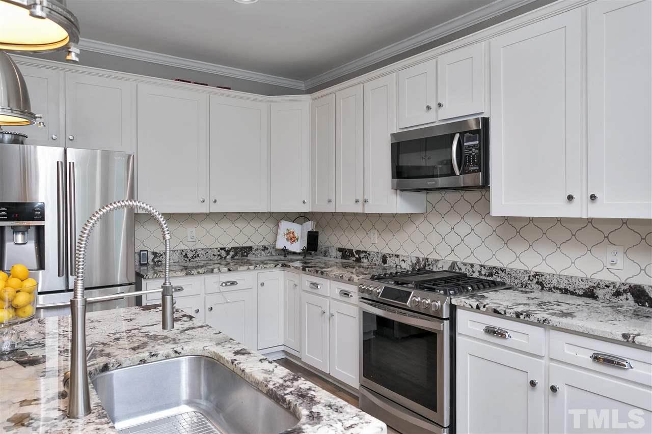 7206 Doverton Court Raleigh, NC 27615 - Photo 8 of 23 a kitchen with stainless steel appliances granite countertop a sink stove and microwave