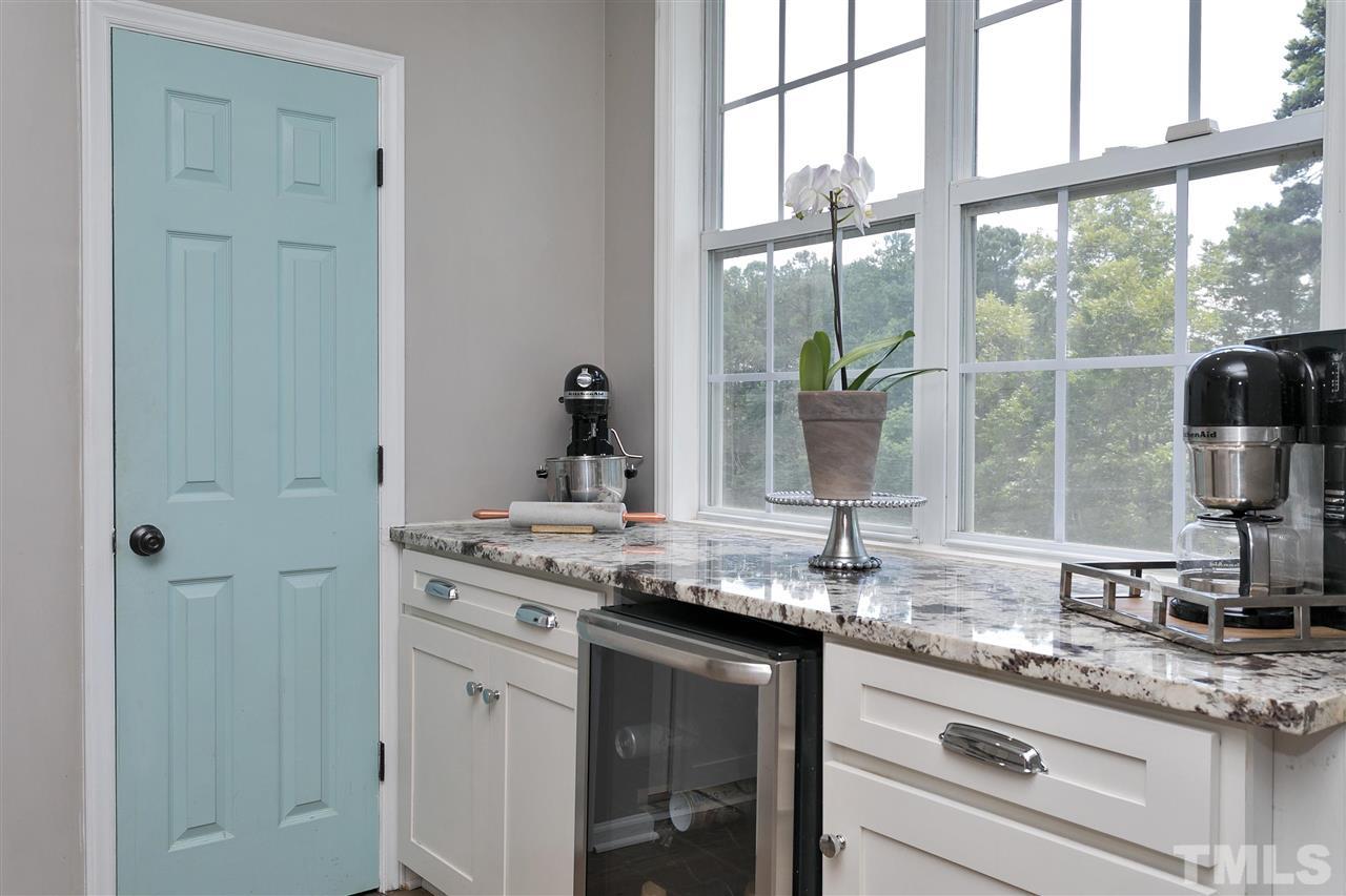 7206 Doverton Court Raleigh, NC 27615 - Photo 9 of 23 a kitchen with stainless steel appliances granite countertop white cabinets and a large window