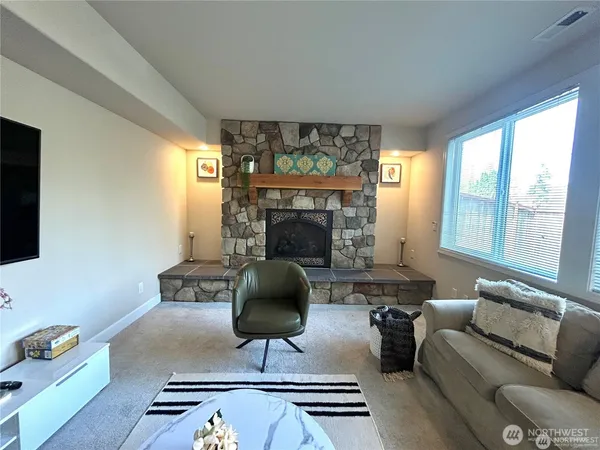a living room with furniture a fireplace and a large window