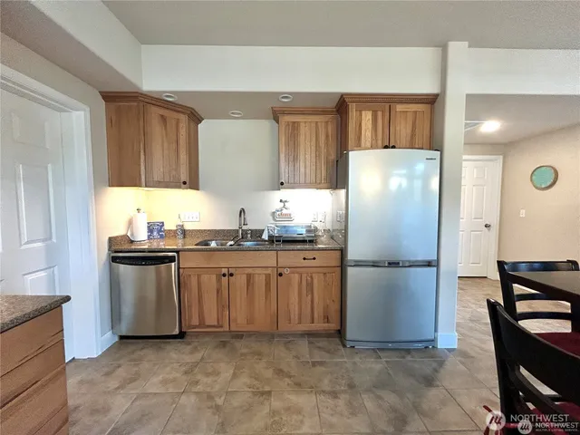 a kitchen with stainless steel appliances granite countertop a refrigerator sink and cabinets