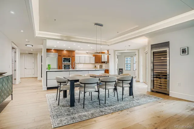 a dining hall with stainless steel appliances granite countertop a dining table chairs and granite counter tops