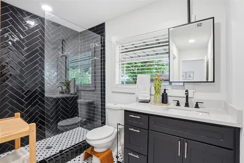 a bathroom with a sink mirror vanity and toilet
