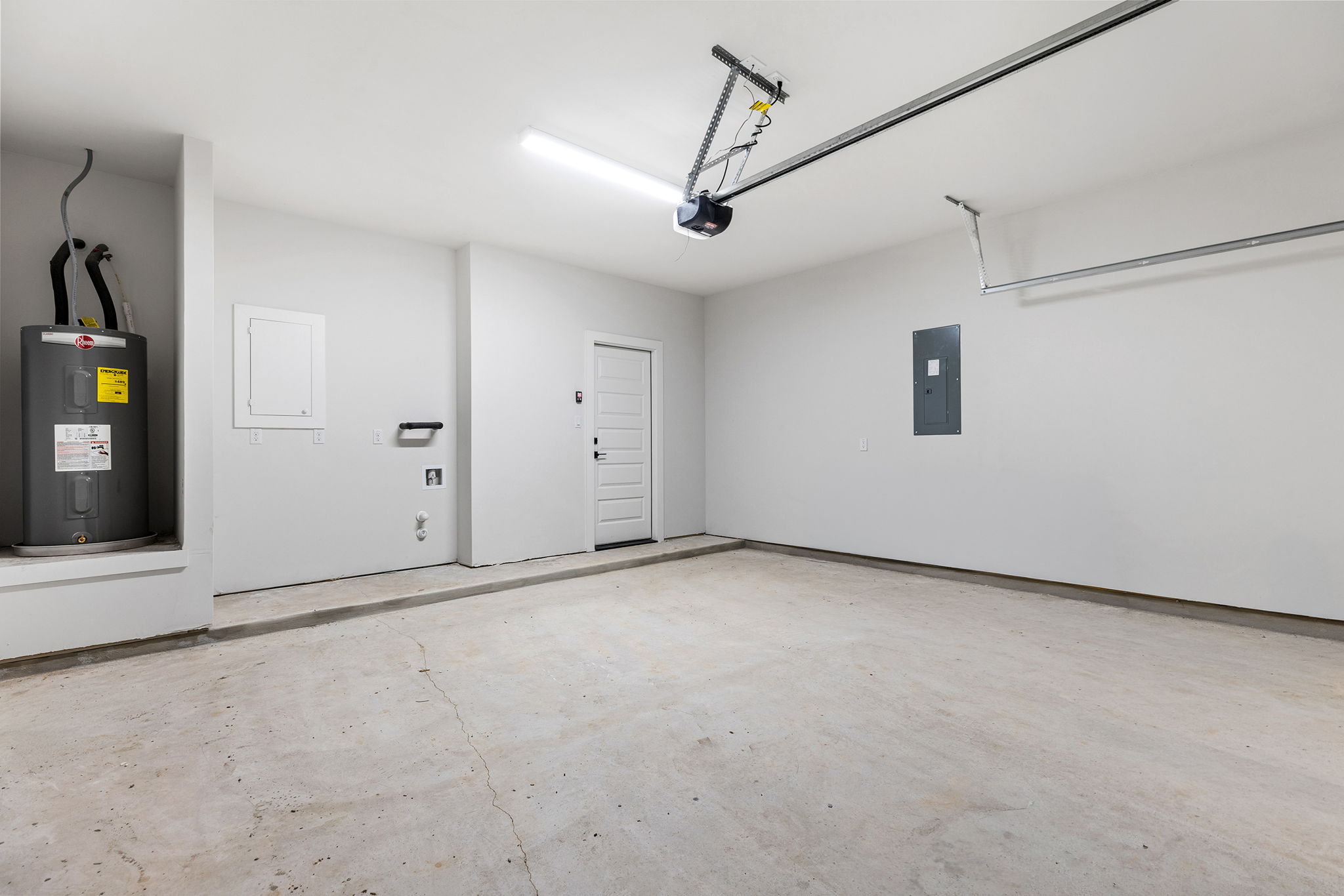 2600 Gattis School Road, Unit 1002 Round Rock, TX 78664 - Photo 31 of 40 A spacious, pristine garage featuring a reliable water heater and seamless entry access.