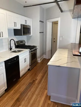 a kitchen with a stove and a hallway