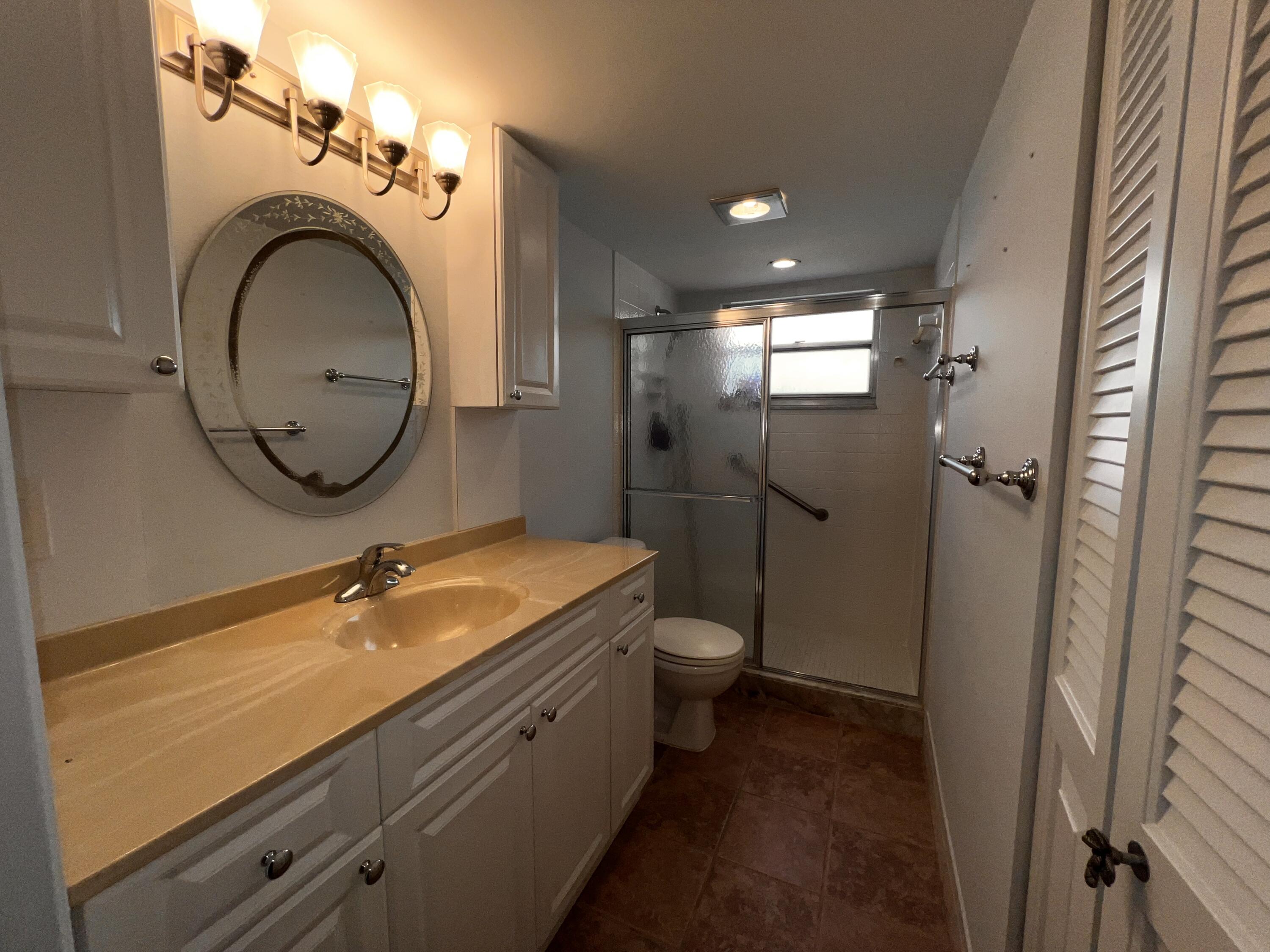 2403 Antigua Circle, Unit O2 Coconut Creek, FL 33066 - Photo 12 of 31 a bathroom with a granite countertop toilet sink and mirror