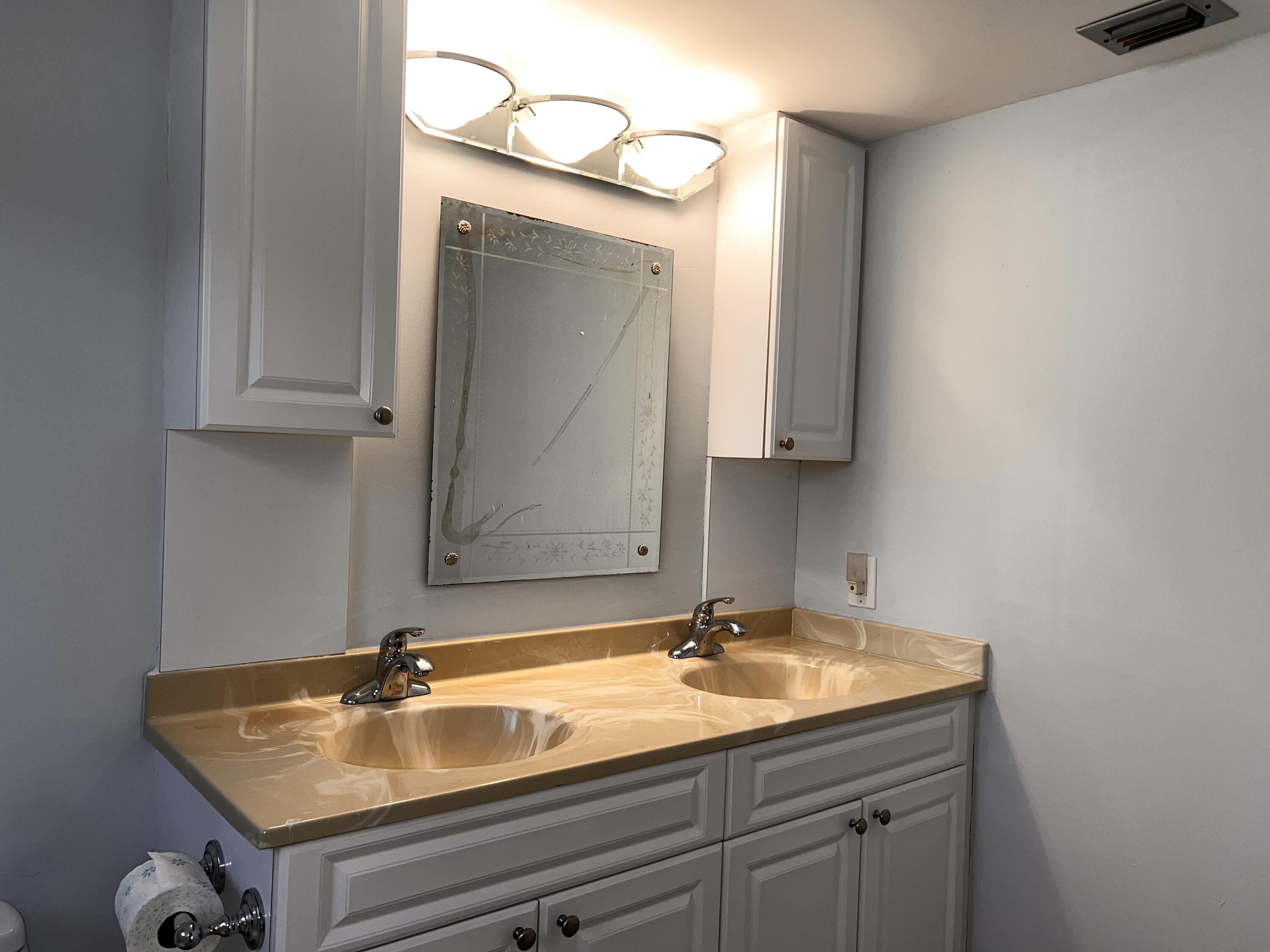 2403 Antigua Circle, Unit O2 Coconut Creek, FL 33066 - Photo 22 of 31 a bathroom with a sink and a mirror