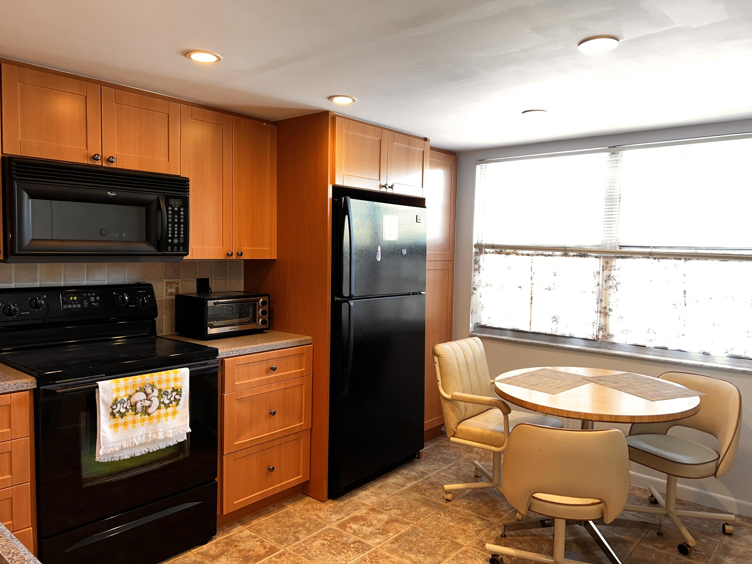 2403 Antigua Circle, Unit O2 Coconut Creek, FL 33066 - Photo 6 of 31 a kitchen with stainless steel appliances granite countertop a refrigerator a stove a sink and a microwave