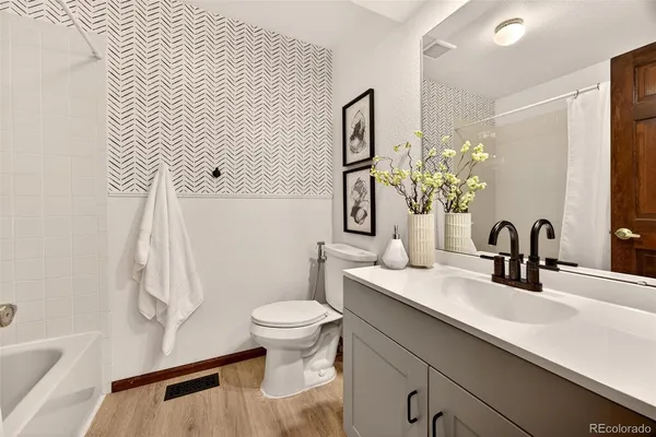 a bathroom with a sink a toilet and mirror