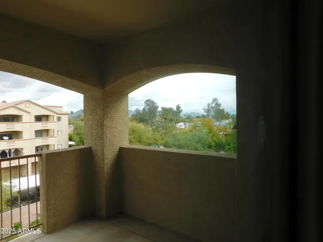 a view of a balcony with wooden floor and fence