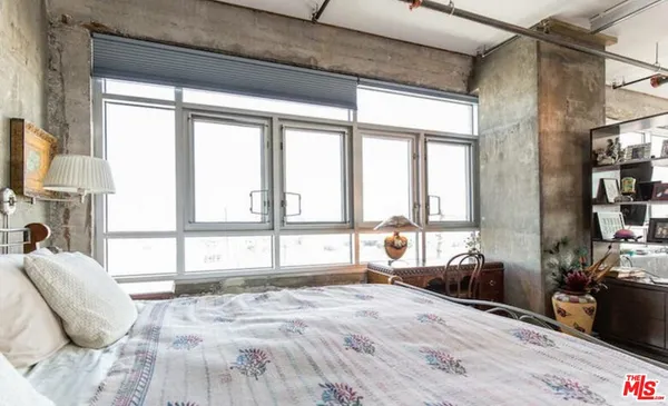 a large bed sitting in a bedroom next to a window