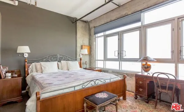 a bed sitting in a bedroom next to a window