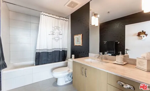 a bathroom with a granite countertop sink toilet and shower