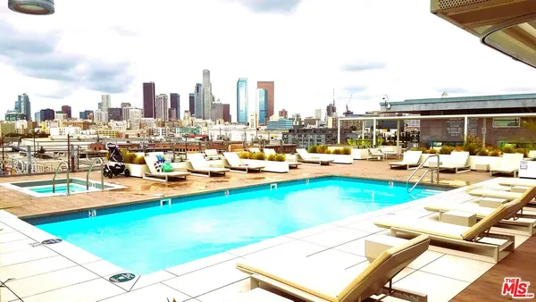 a view of swimming pool with outdoor seating and a garden