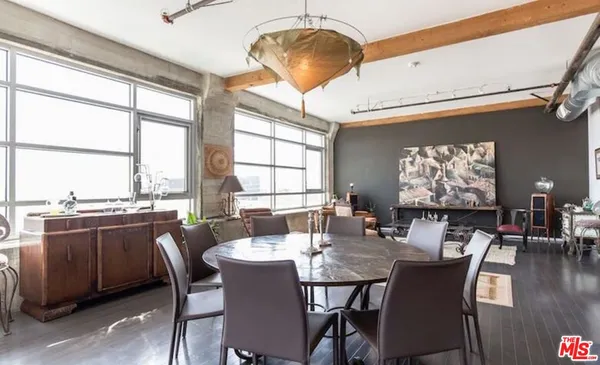 a dining room with wooden floor a chandelier fan a wooden table and chairs