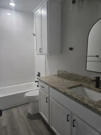 a bathroom with a granite countertop sink toilet and shower