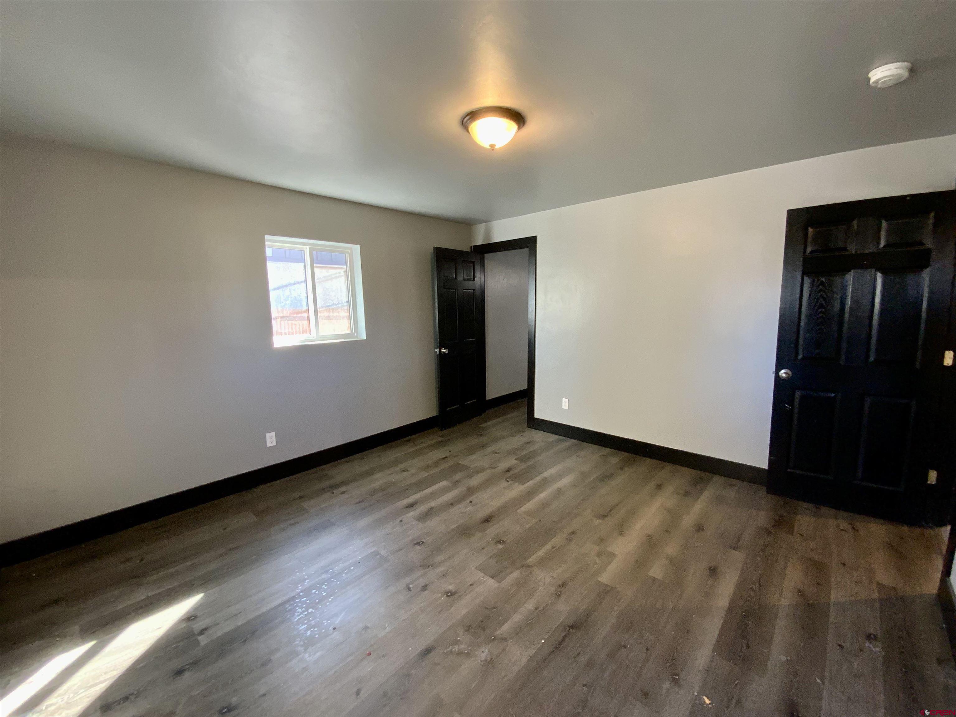 1511 West Tomichi Avenue Gunnison, CO 81230 - Photo 13 of 20 an empty room with wooden floor and windows