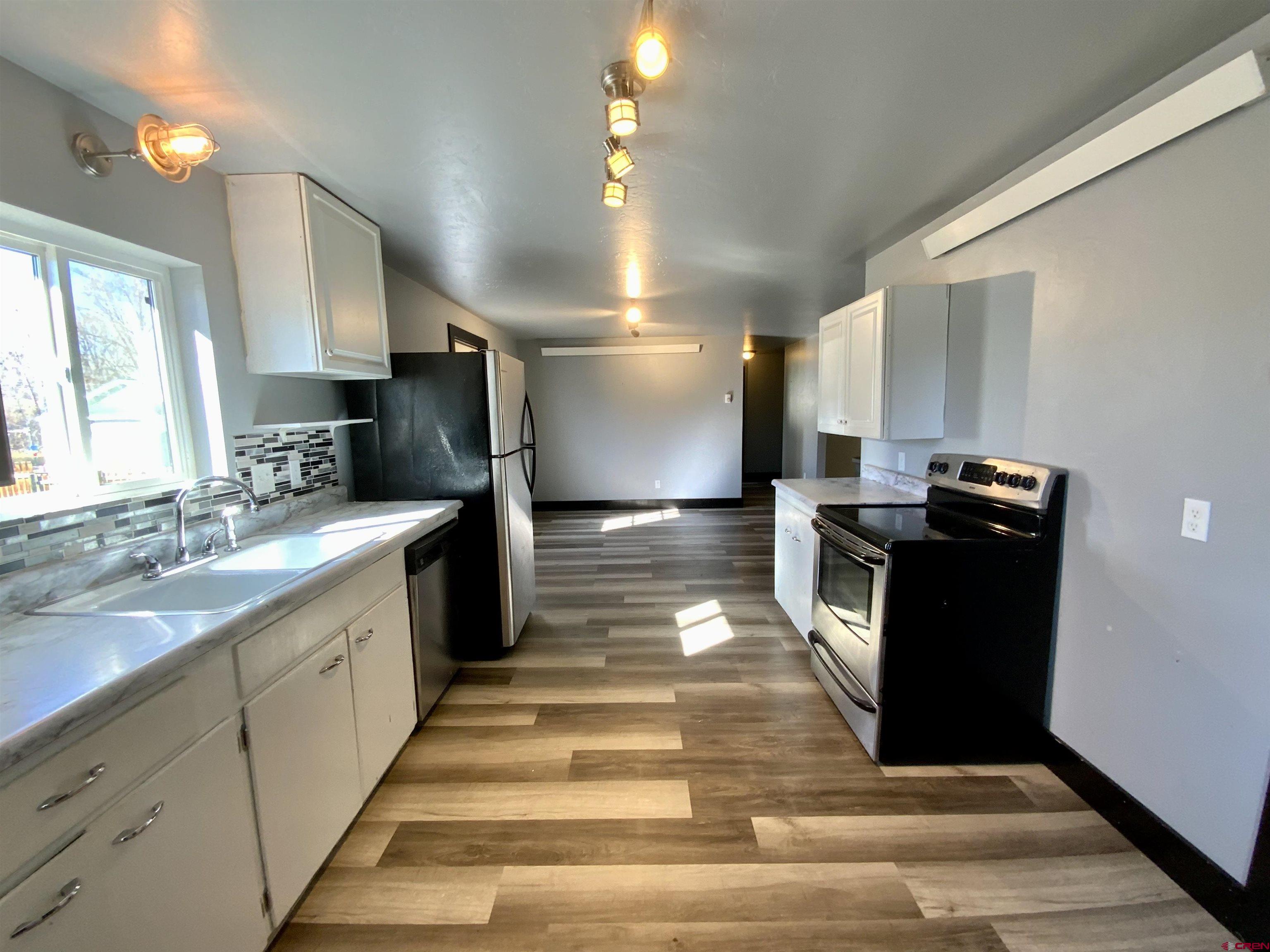 1511 West Tomichi Avenue Gunnison, CO 81230 - Photo 5 of 20 a view of a kitchen with cabinets and wooden floor