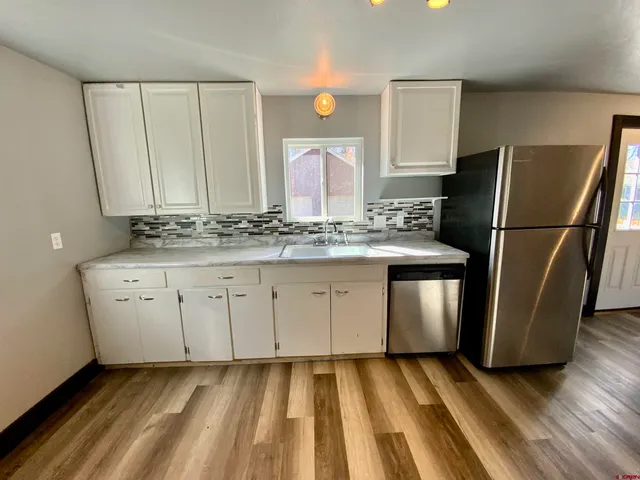 a kitchen with a sink a refrigerator and a stove