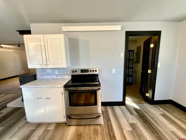a kitchen with a stove and white cabinets