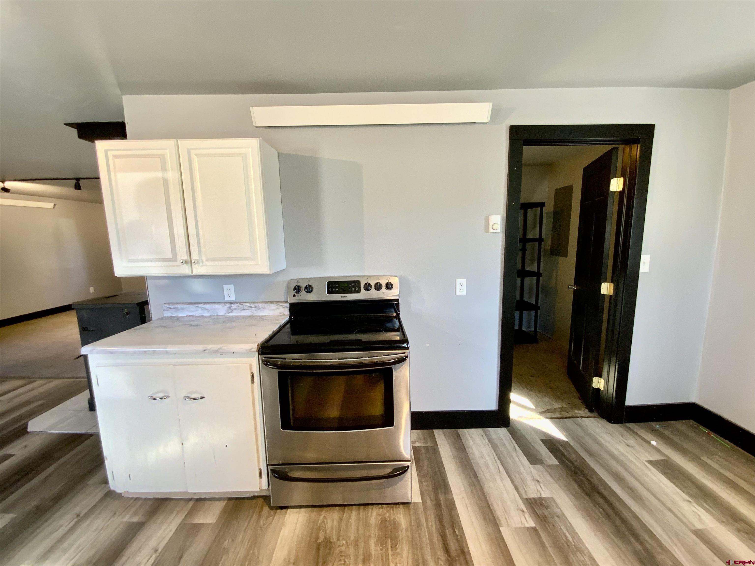 1511 West Tomichi Avenue Gunnison, CO 81230 - Photo 7 of 20 a kitchen with a stove and white cabinets