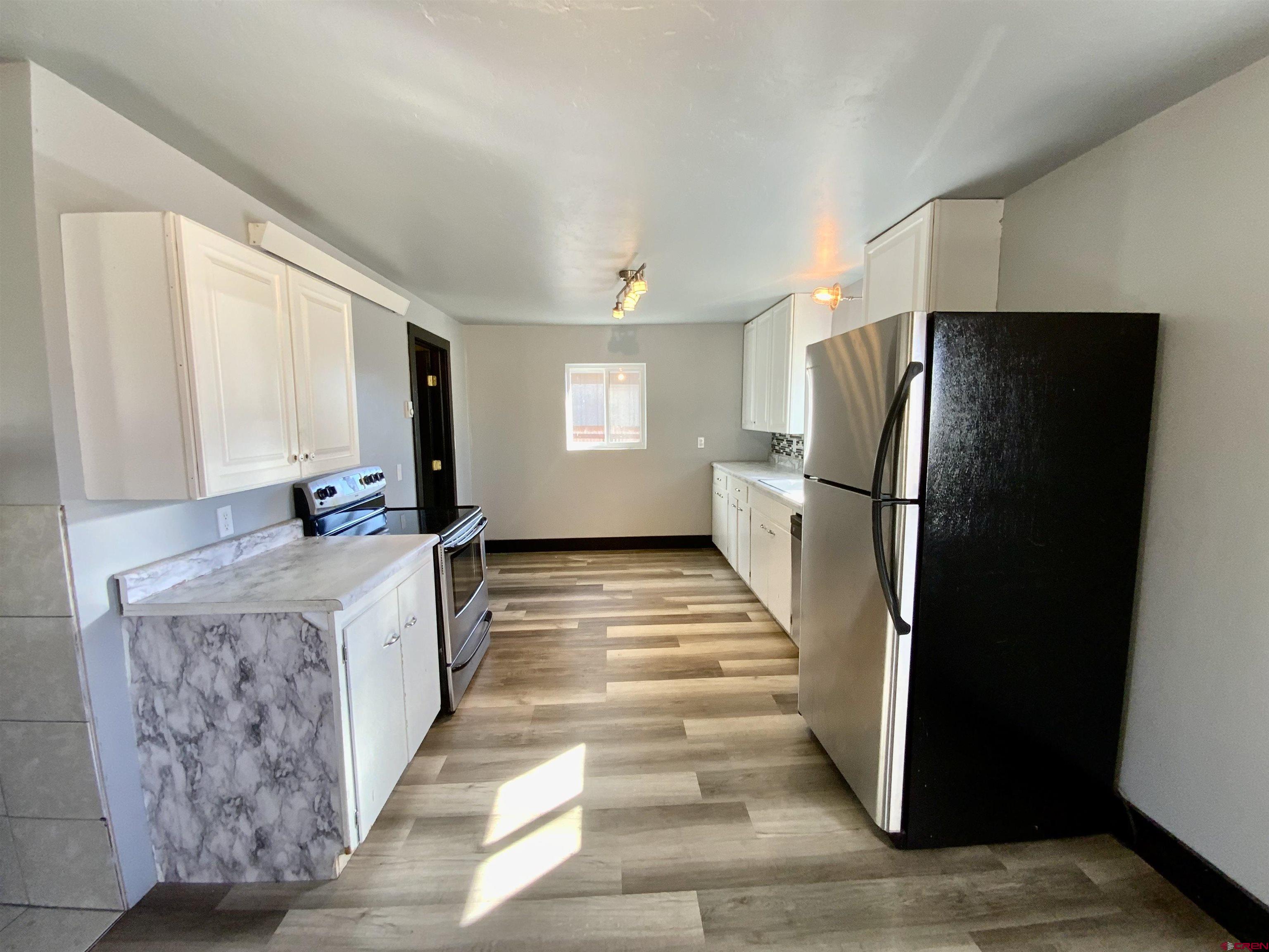 1511 West Tomichi Avenue Gunnison, CO 81230 - Photo 8 of 20 a kitchen with stainless steel appliances granite countertop a refrigerator and a stove