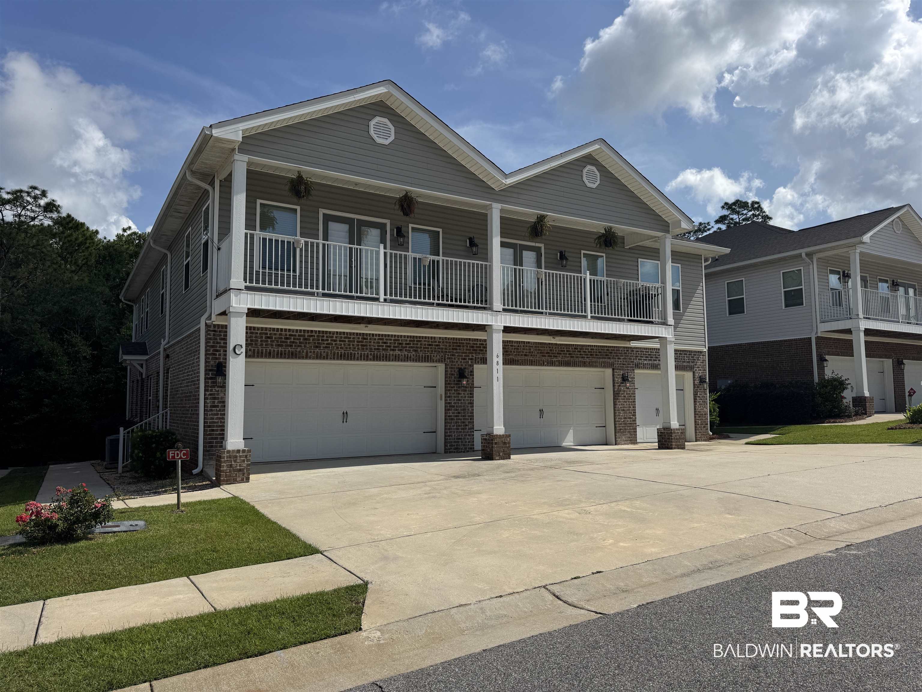 6811 Spaniel Drive, Unit C Daphne, AL 36527 - Photo 1 of 33 View of front of house with a garage, brick siding, and driveway