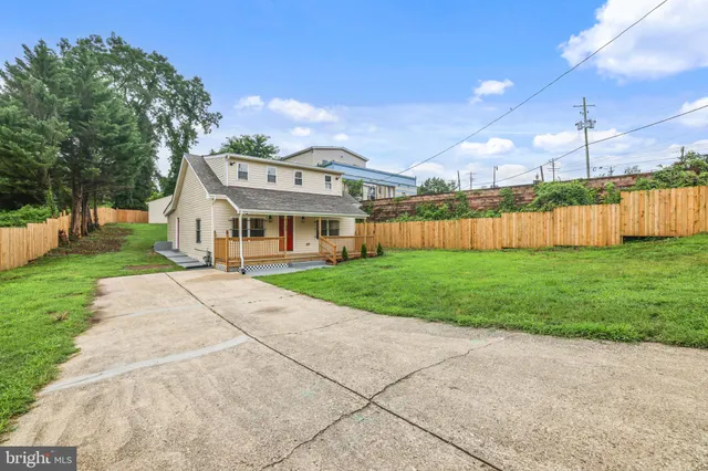 a view of a house with a big yard and large trees