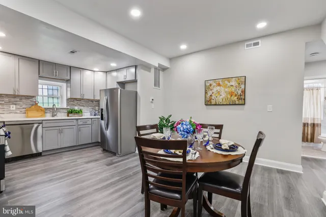 a kitchen with a dining table chairs refrigerator and cabinets