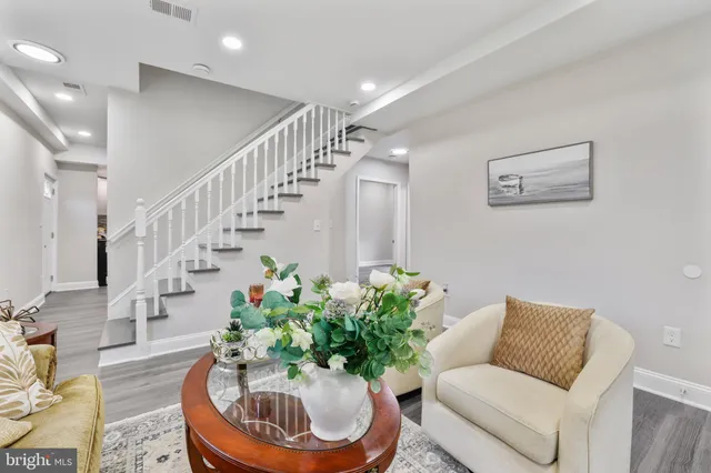 a living room with furniture flowers and a chandelier