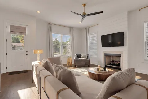 a living room with furniture a fireplace and a flat screen tv