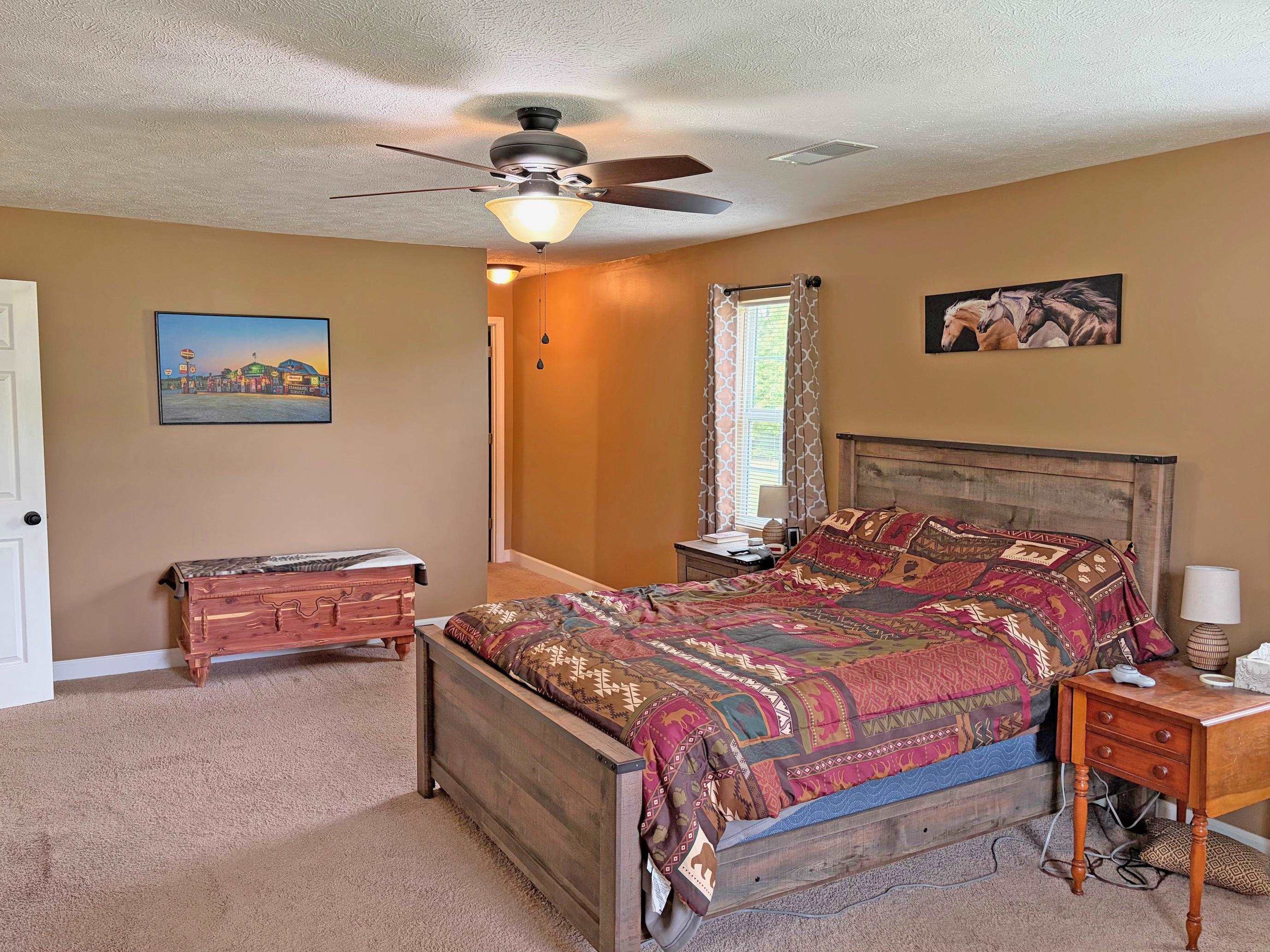 1255 Elm Road Adamsville, TN 38310 - Photo 12 of 32 a bedroom with a bed and a chandelier
