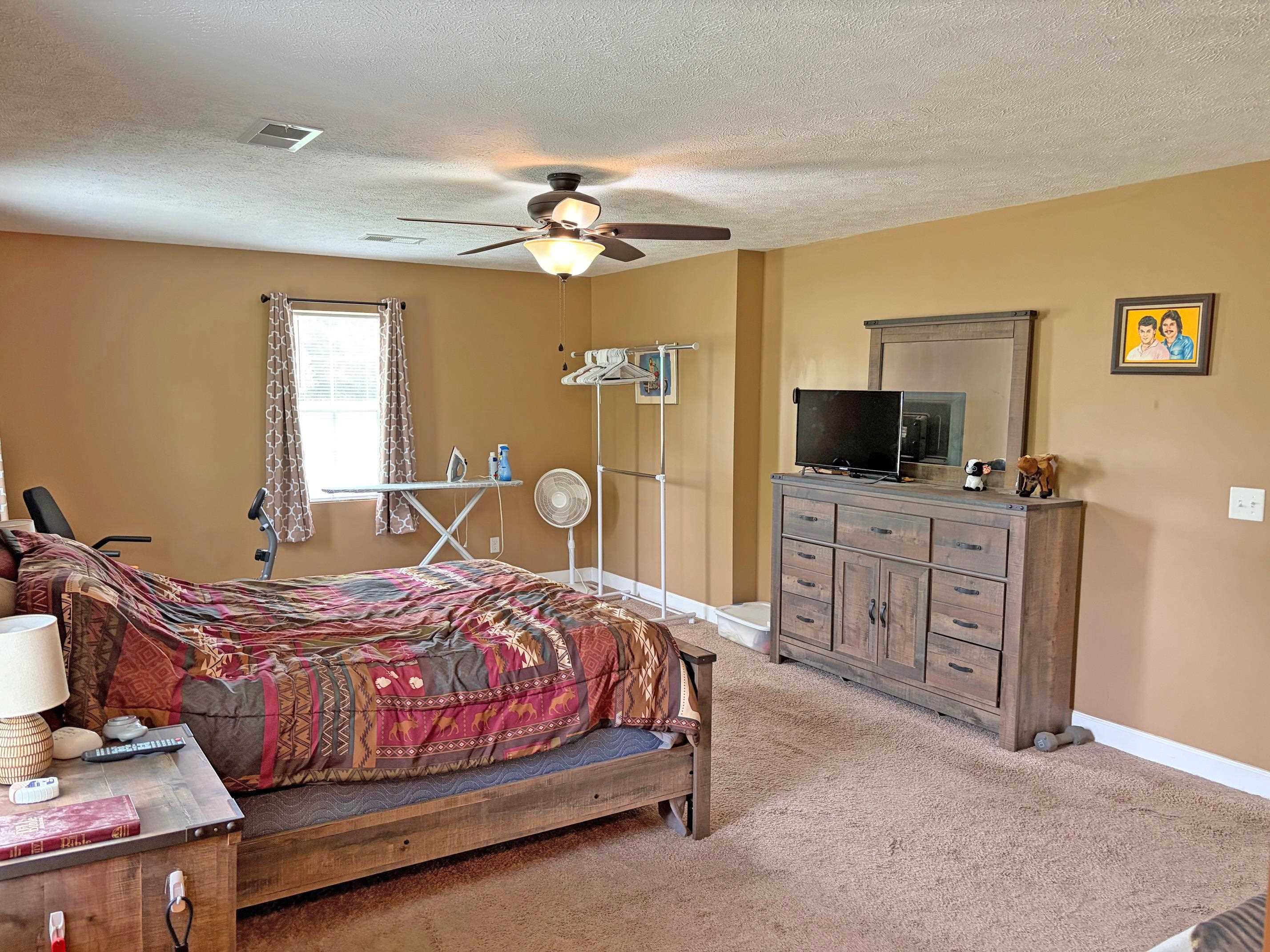 1255 Elm Road Adamsville, TN 38310 - Photo 13 of 32 a bedroom with a bed and a flat screen tv