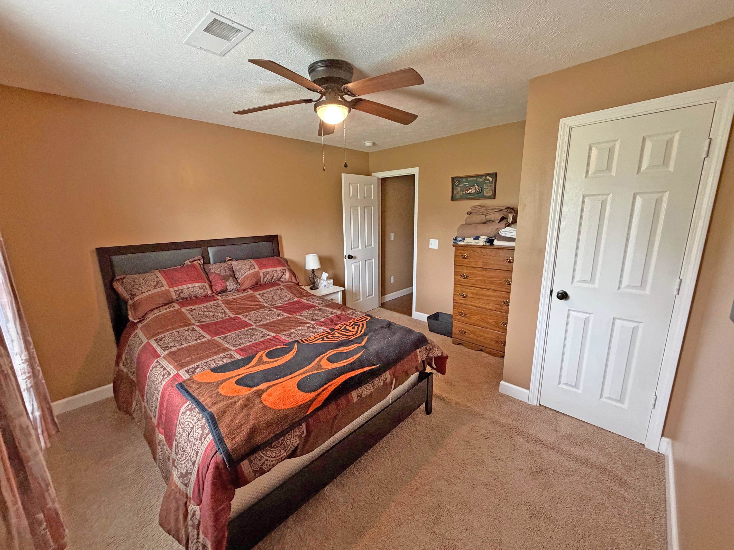 1255 Elm Road Adamsville, TN 38310 - Photo 17 of 32 a bedroom with a bed and a chandelier