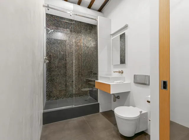 a bathroom with a sink toilet mirror and shower