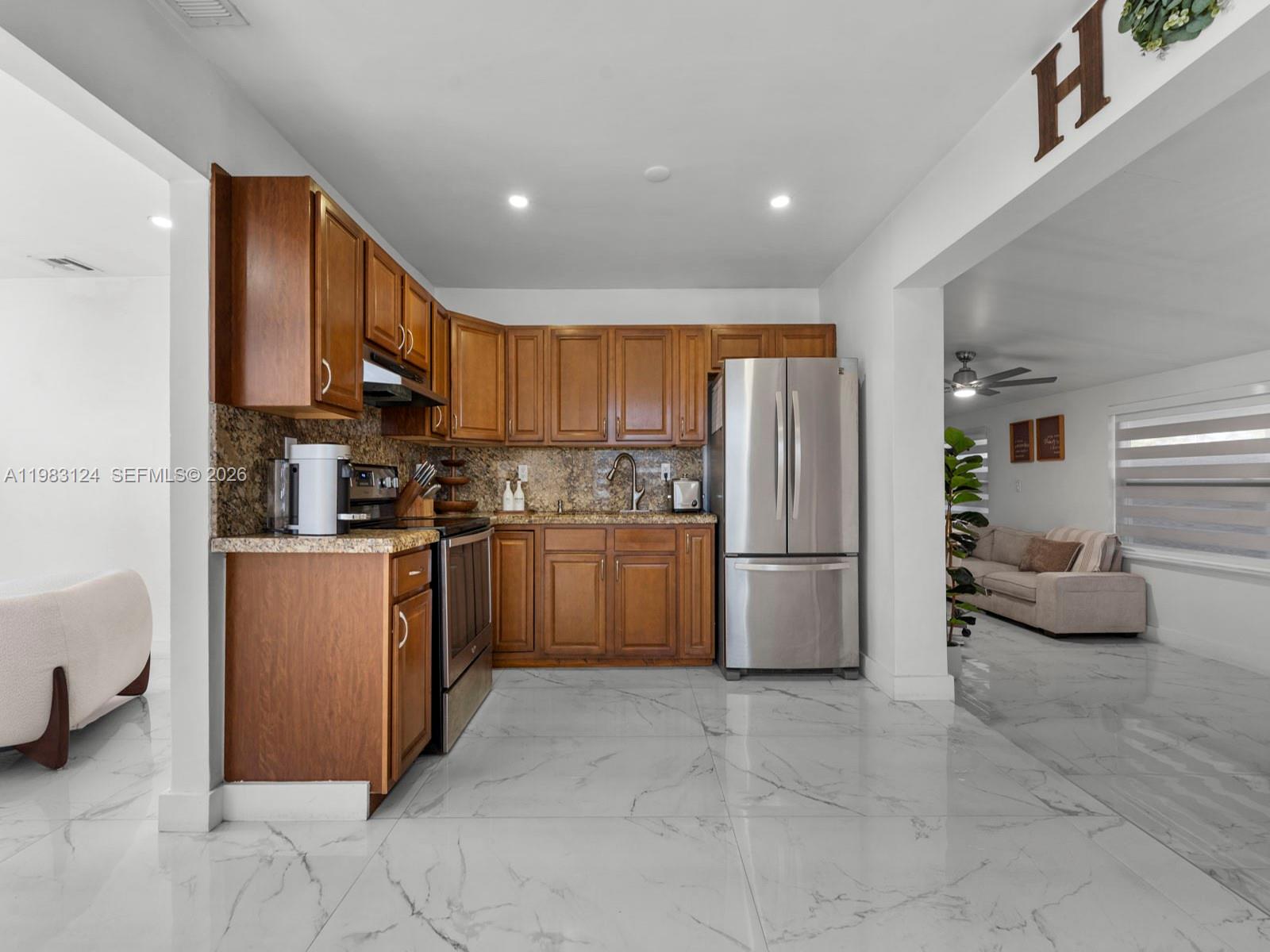 120 West 50th Street Hialeah, FL 33012 - Photo 12 of 37 a kitchen with a refrigerator and a stove top oven