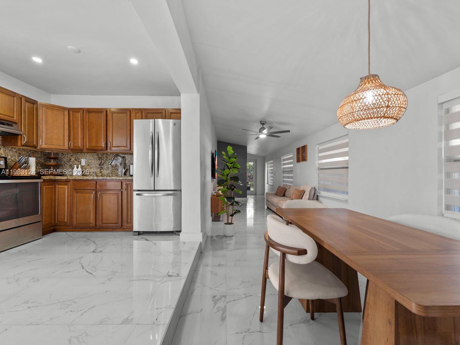 120 West 50th Street Hialeah, FL 33012 - Photo 13 of 37 a kitchen with stainless steel appliances a table and chairs in it