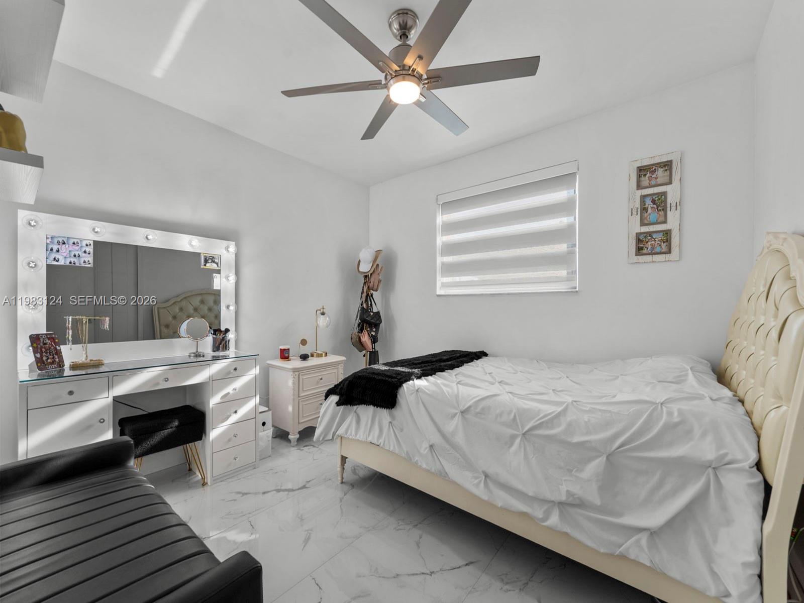 120 West 50th Street Hialeah, FL 33012 - Photo 21 of 37 a bedroom with a bed and a chandelier