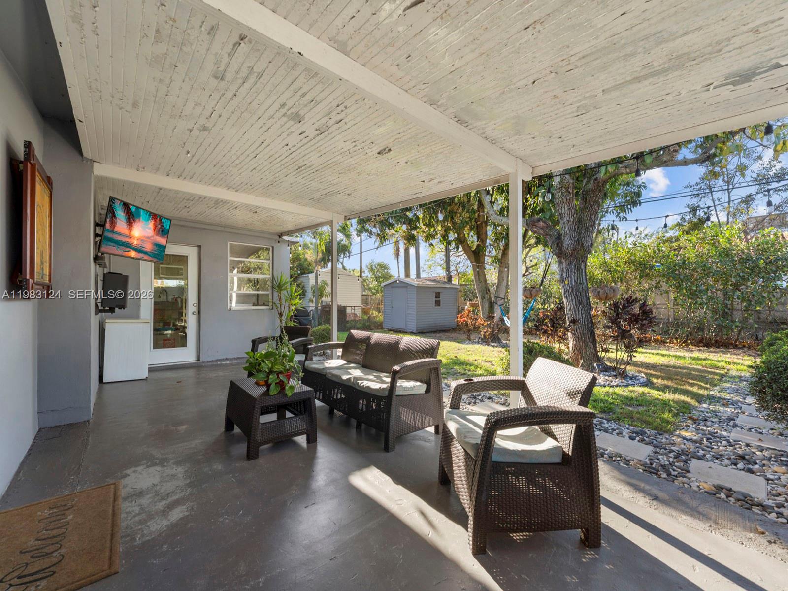 120 West 50th Street Hialeah, FL 33012 - Photo 31 of 37 a living room with patio furniture and a garden