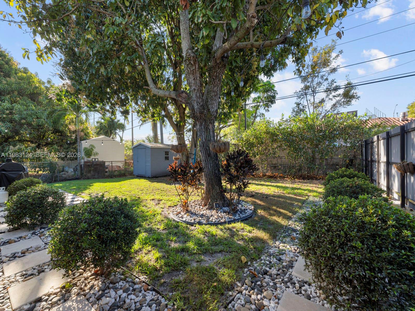120 West 50th Street Hialeah, FL 33012 - Photo 33 of 37 a view of a house with a yard and large trees